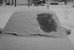 Car covered in snow with only drivers side windsield clear